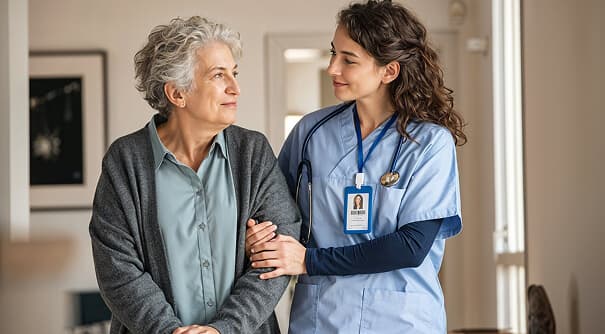 A support worker standing beside an older woman