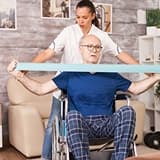 A support worker assisting an older wheelchair user at home