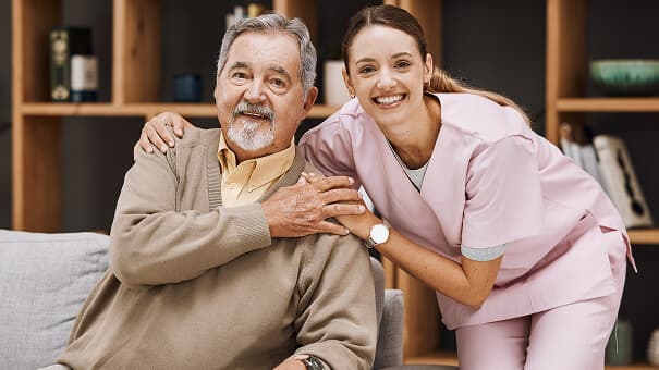 A support worker embracing a smiling older man